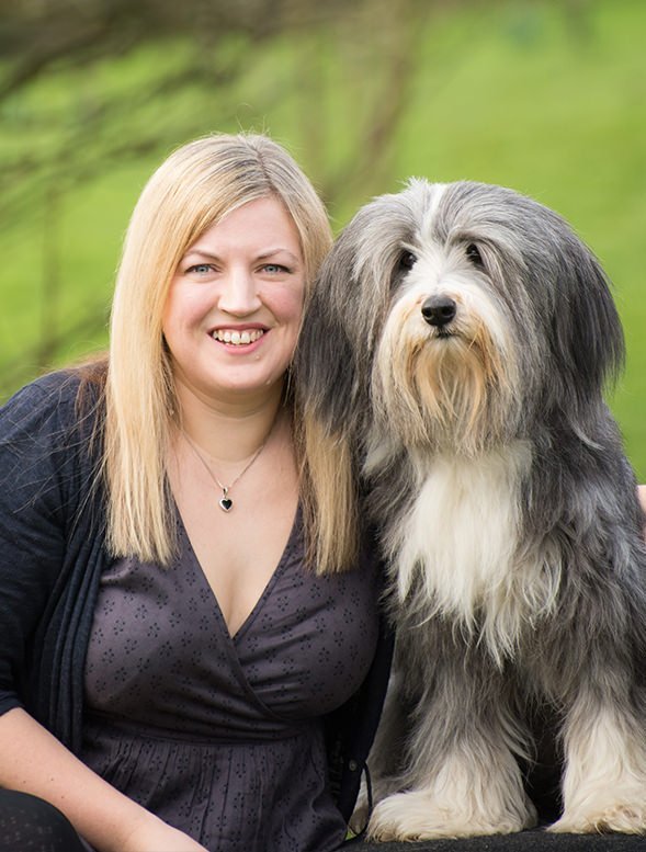 Woman with a long-haired dog in a park setting